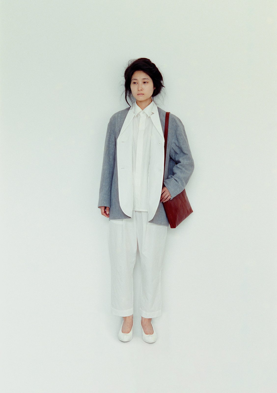 Reversible tailored haori jacket sumi-dyed linen outer with cotton linen typewriter lining, Front-fly shirt and folk pants in the same material as the lining, Naturally-tanned leather conductor bag